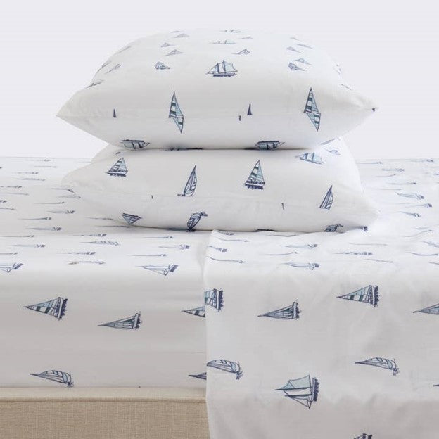 A set of white microfiber sheets with a sailboat pattern, displayed with a king-size mattress and pillows.