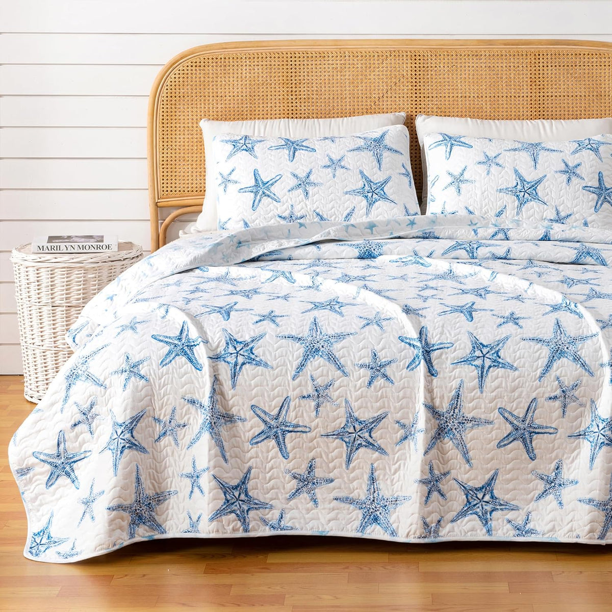 A lightweight quilt set featuring a coastal starfish design in blue on a white background, with two matching pillow shams.  Known as the Trinidad C3 piece Collection.