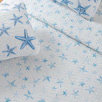 A lightweight quilt set featuring a coastal starfish design in blue on a white background, with two matching pillow shams.  Known as the Trinidad C3 piece Collection.
