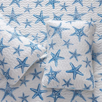 A lightweight quilt set featuring a coastal starfish design in blue on a white background, with two matching pillow shams.  Known as the Trinidad C3 piece Collection.