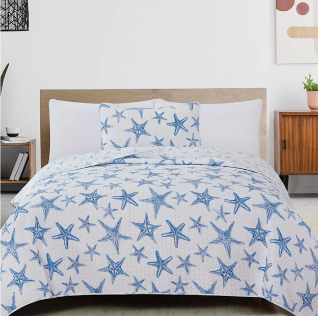 A lightweight quilt set featuring a coastal starfish design in blue on a white background, with two matching pillow shams.  Known as the Trinidad C3 piece Collection.
