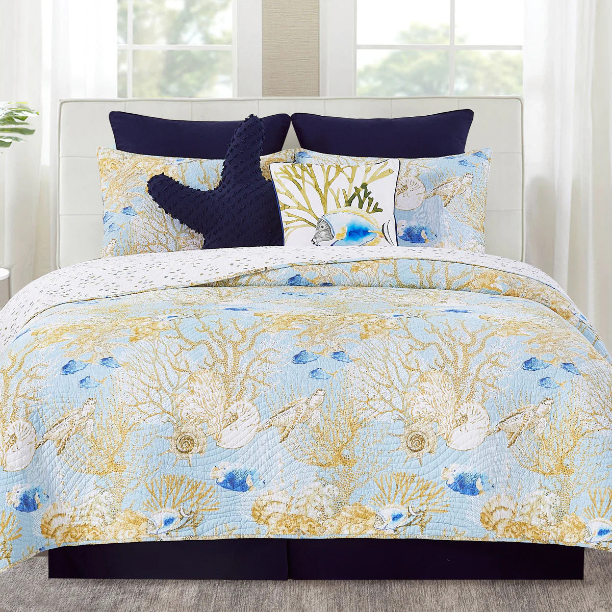 A bedding set surrounded by coastal fish and vibrant coral reefs fill the design, while turtles glide gracefully through the reefs, surrounded by seashells. The wave stitching adds an extra touch of coastal charm, giving the quilt a relaxed, beachy vibe