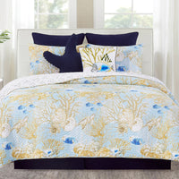 A bedding set surrounded by coastal fish and vibrant coral reefs fill the design, while turtles glide gracefully through the reefs, surrounded by seashells. The wave stitching adds an extra touch of coastal charm, giving the quilt a relaxed, beachy vibe