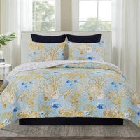 A bedding set surrounded by coastal fish and vibrant coral reefs fill the design, while turtles glide gracefully through the reefs, surrounded by seashells. The wave stitching adds an extra touch of coastal charm, giving the quilt a relaxed, beachy vibe