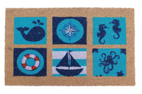 A rectangular coir outdoor door mat with nautical designs including a whale, a lifebuoy, and a sailboat, placed on a doorstep.