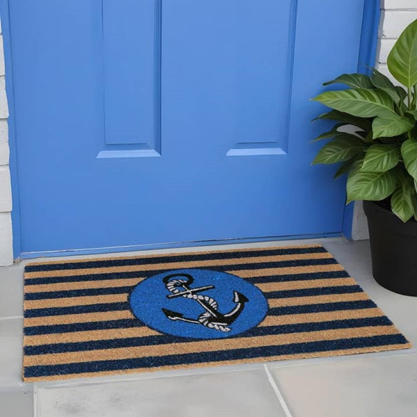 A coir door mat with blue stripes and a central anchor design, placed on a doorstep.