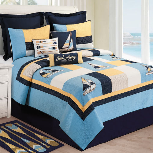 Nautical sailboat bedding set with blue, yellow, and black colors on a bed.