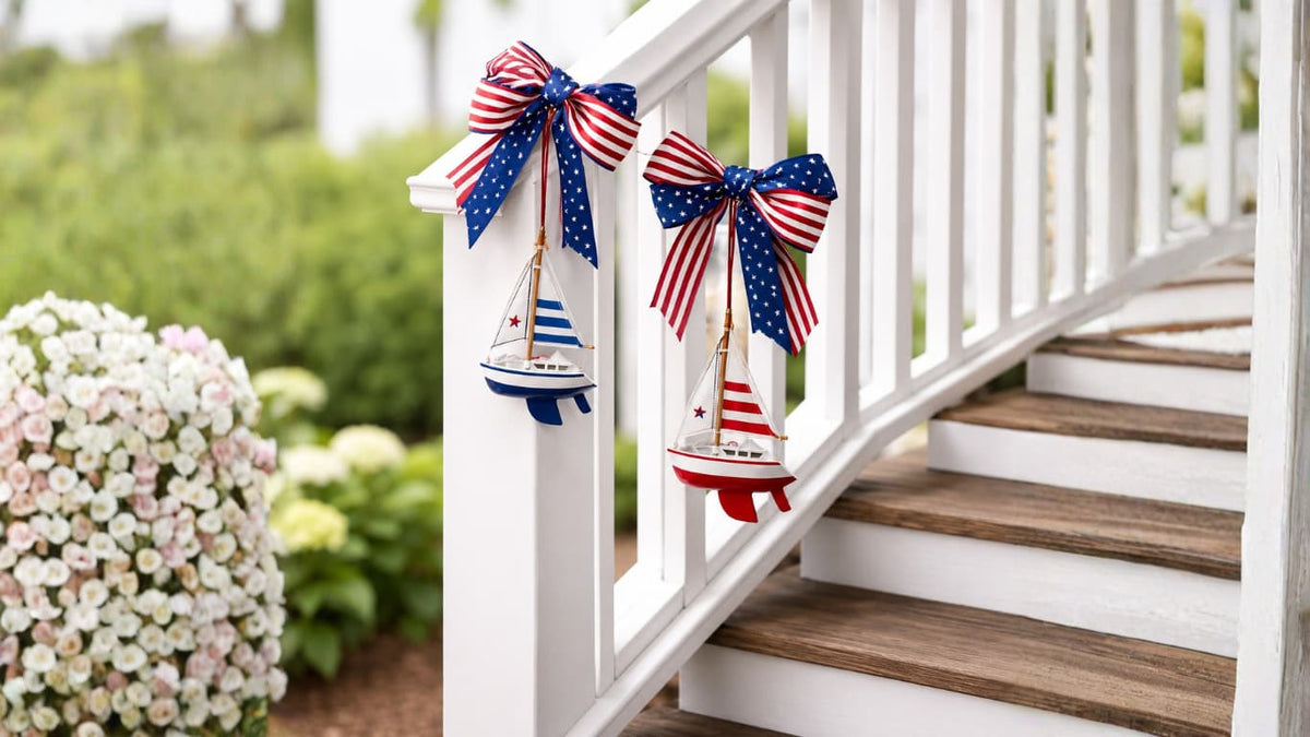 Wooden Blue Sailboat Ornaments with Blue Striped Sails on a Christmas tree with lights adorned with decorative bows with American flag patterns on a white railing with wooden steps.