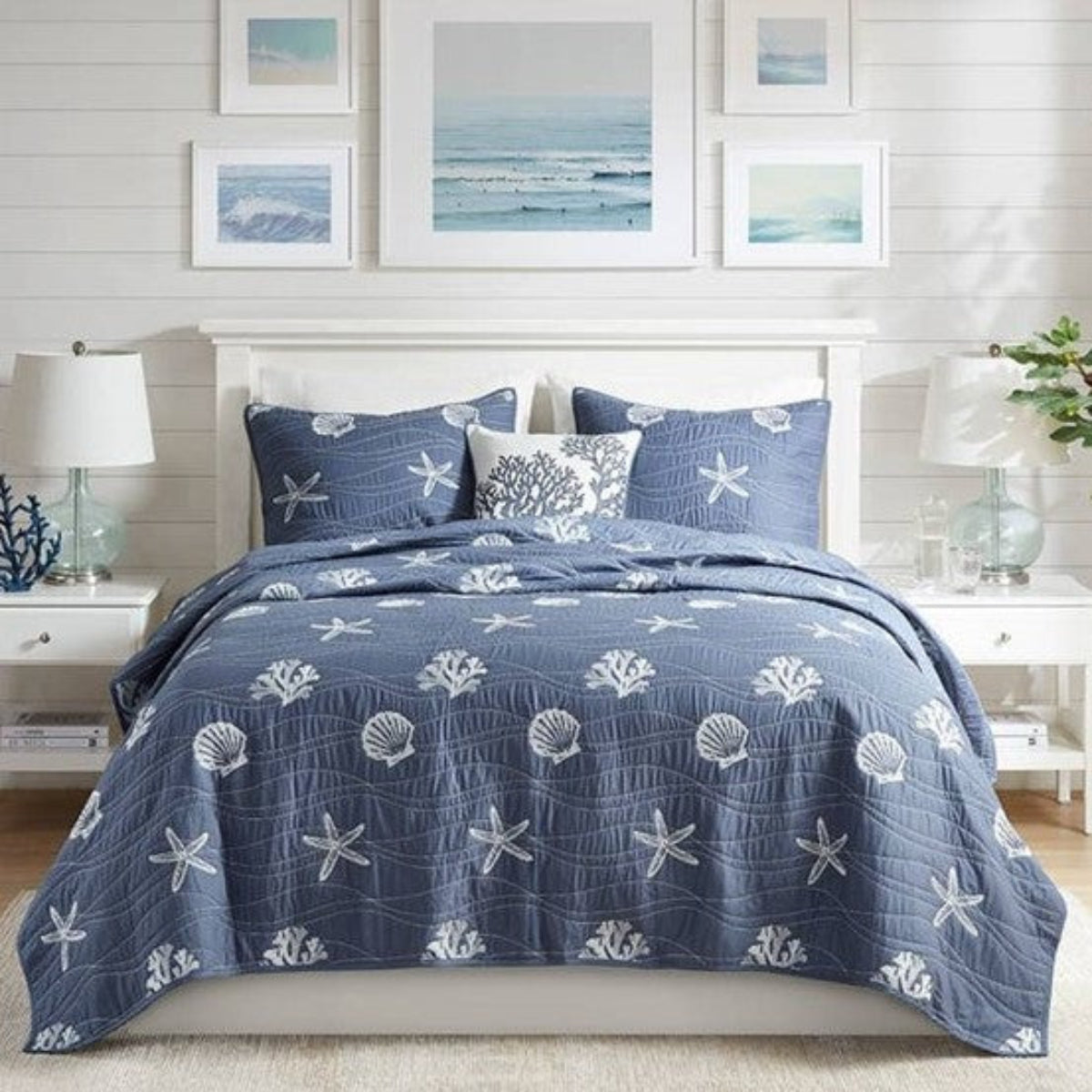 Nautical-themed bedding set with starfish and shell patterns on a bed in a bedroom setting.