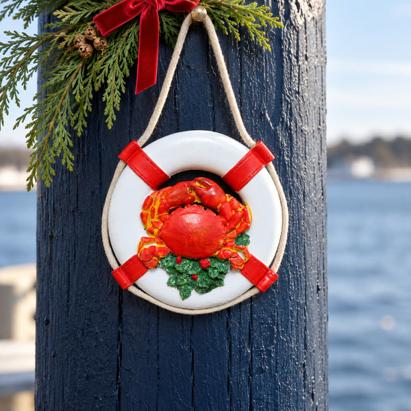 Life preserver Christmas ornament with a red crab hanging from a pole on the dock.