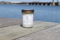 Coastal Scented Soy Wax Candle on a dock surrounded by water
