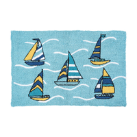 A rectangular blue rug featuring a nautical design with five colorful sailboats and white wavy lines representing water, shown on a plain white background.