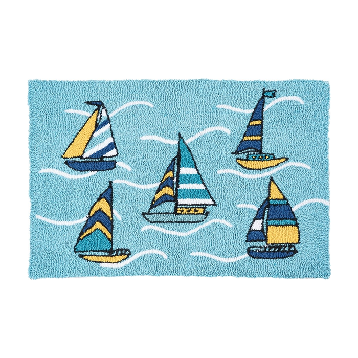 A rectangular blue rug featuring a nautical design with five colorful sailboats and white wavy lines representing water, shown on a plain white background.