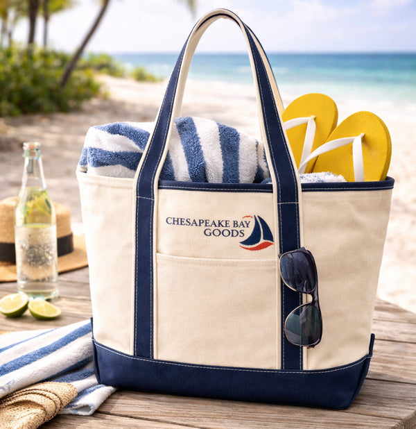 Natural canvas navy tote with beach items by the beach.