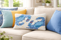 Decorative pillows with blue crab pattern on a beige sofa
